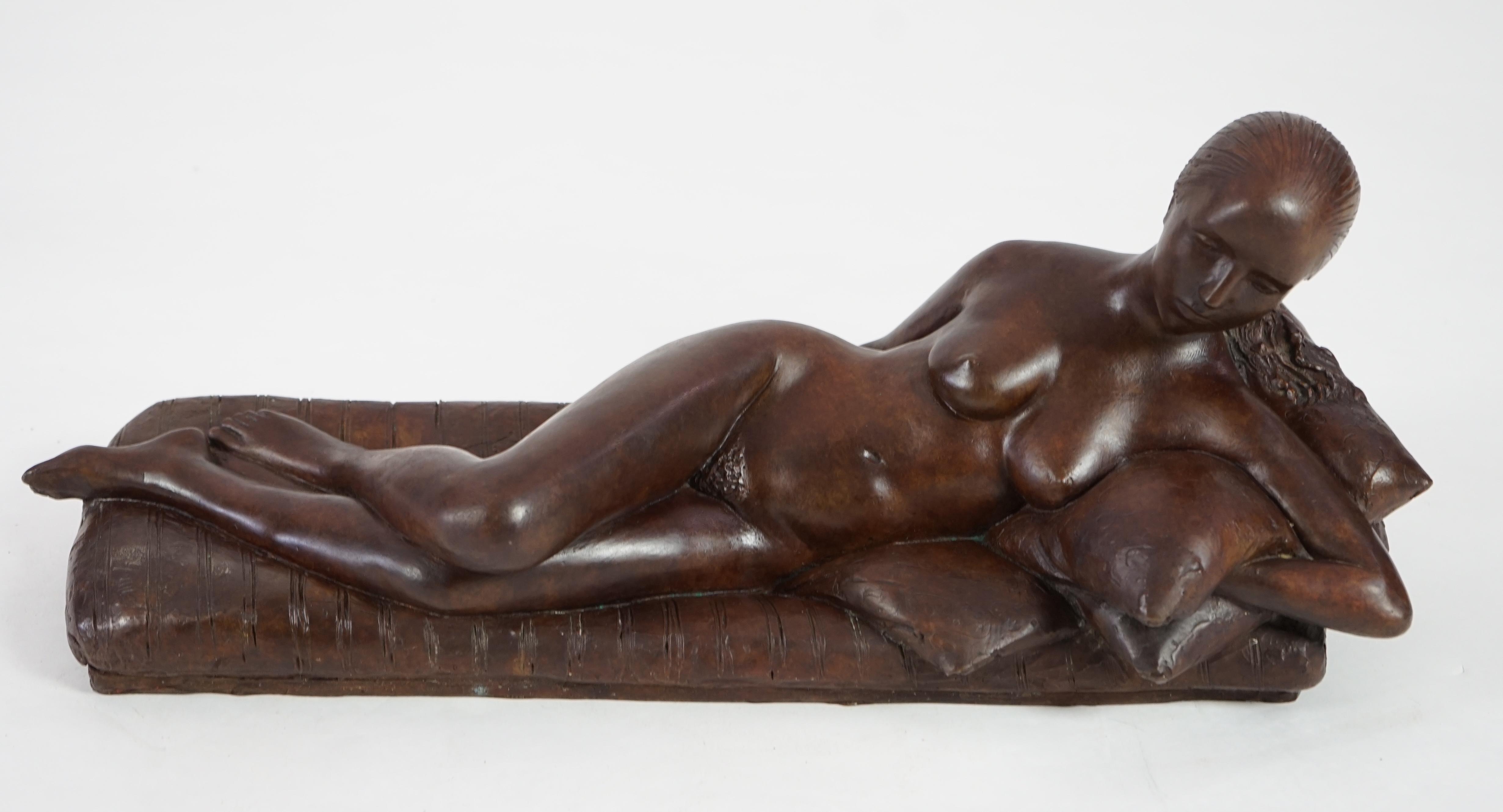 James Butler (1931-2022). A bronze figure of a female nude reclining upon cushions